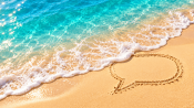 Sunny beach scene with a gentle chat-bubble wave in golden sand, representing the best time to send SMS