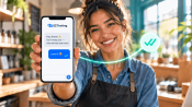 Smiling small-business owner holding a phone showing an EZ Texting message to customers, with a read-receipt checkmark