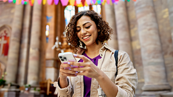 Image of woman on phone outside of church